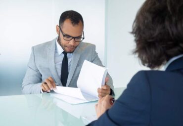 businessman-reading-contract-during-meeting